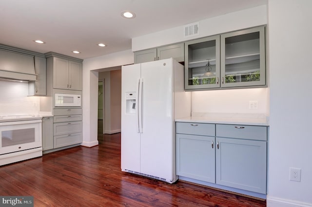 kitchen with white appliances, gray cabinetry, dark wood-type flooring, glass insert cabinets, and recessed lighting