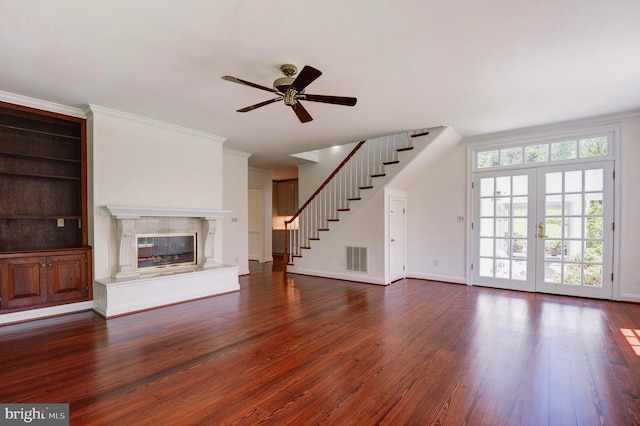 unfurnished living room with stairs, dark wood finished floors, ceiling fan, a premium fireplace, and baseboards