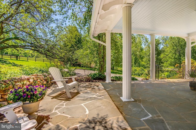 view of patio with fence and view of scattered trees