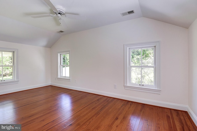 spare room with vaulted ceiling, wood-type flooring, baseboards, and a ceiling fan