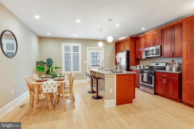 1716 M St NE, Washington, DC 20002 - kitchen featuring stainless steel appliances, a breakfast bar, light wood-style floors, a center island with sink, and recessed lighting