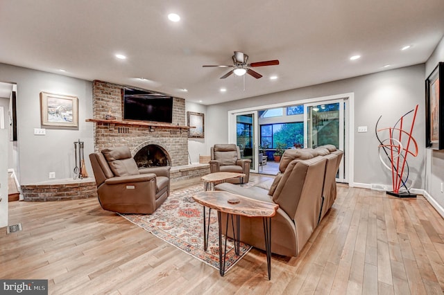 living room with a ceiling fan, light wood-style flooring, a brick fireplace, recessed lighting, and baseboards