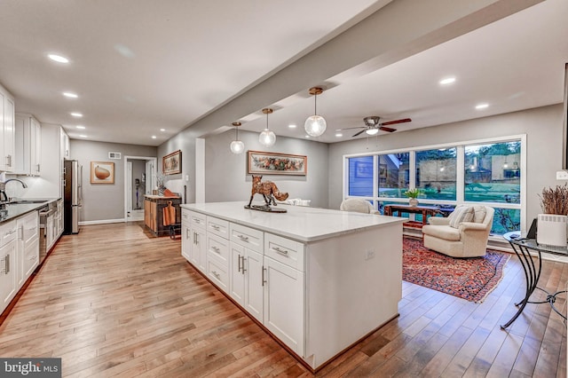 kitchen with light wood-style flooring, a ceiling fan, white cabinets, and recessed lighting