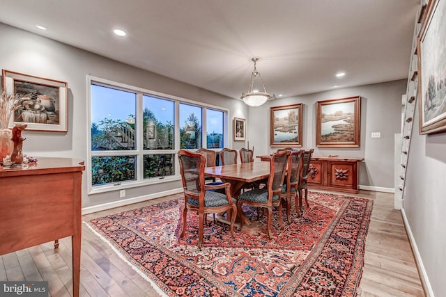 dining space featuring light wood finished floors, baseboards, and recessed lighting