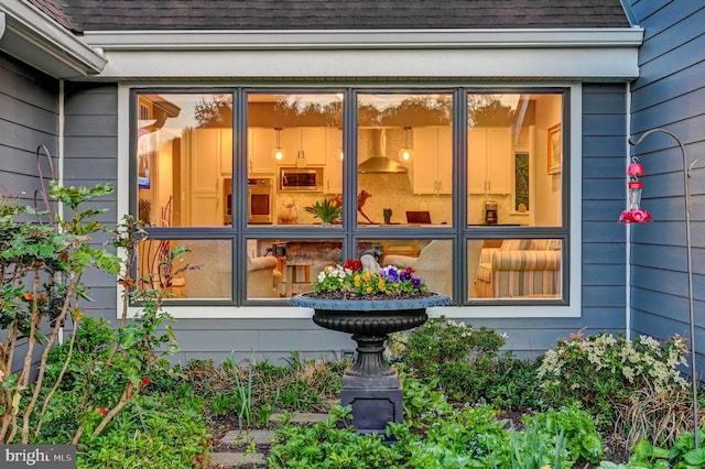 doorway to property with a shingled roof