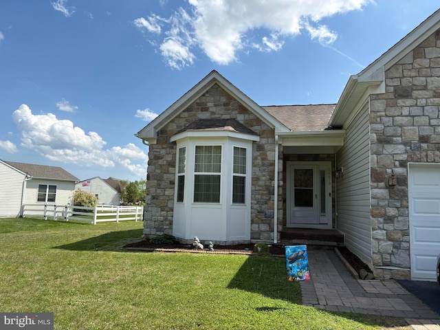 view of exterior entry featuring stone siding and a shingled roof