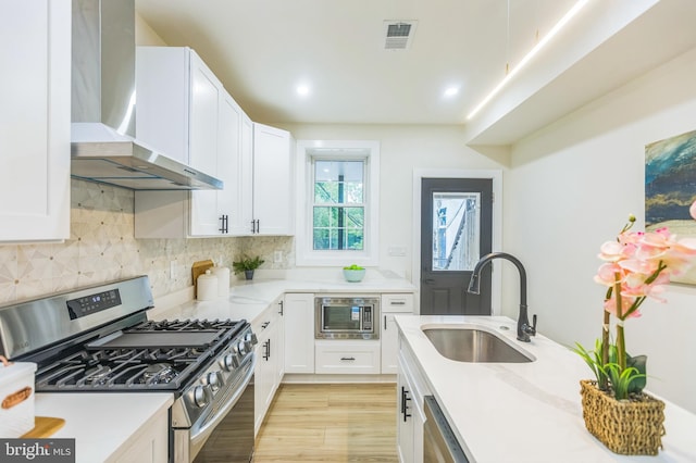 1129 8th St NE, Washington, DC 20002 - kitchen with stainless steel appliances, a sink, wall chimney range hood, light countertops, and recessed lighting