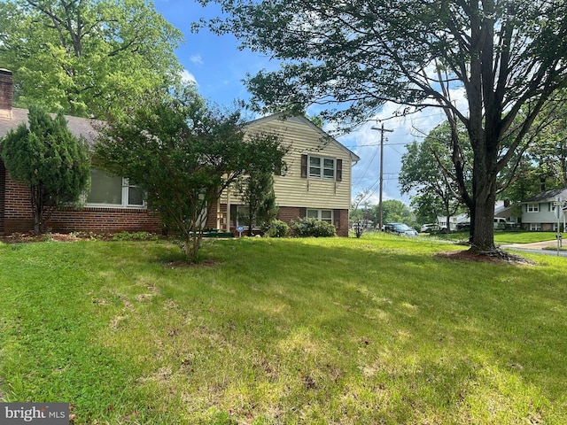 view of front of property with a front yard and brick siding