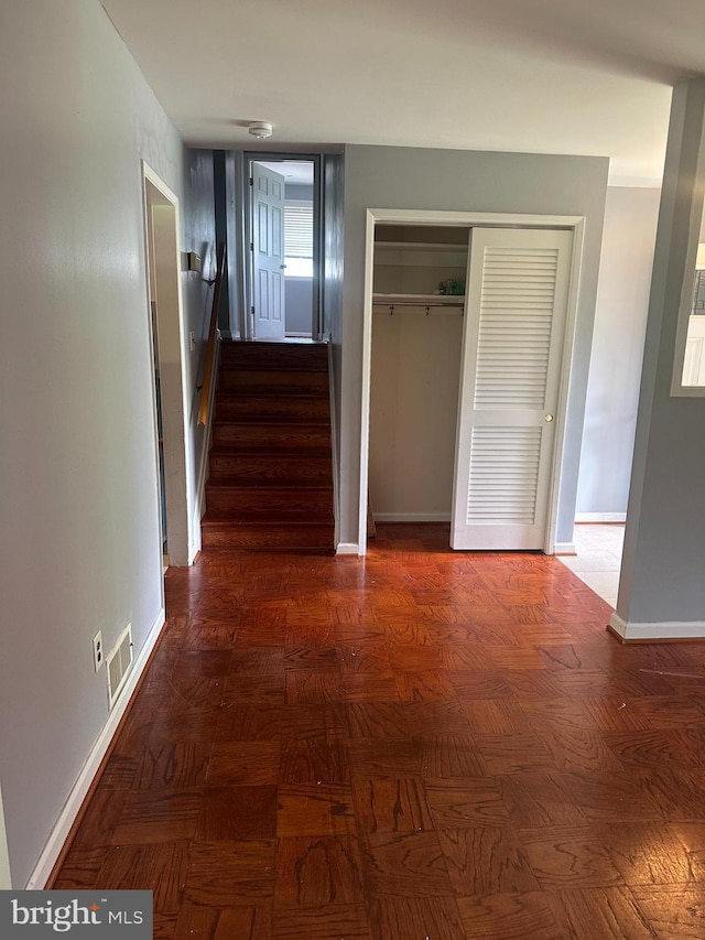 corridor featuring stairway and baseboards