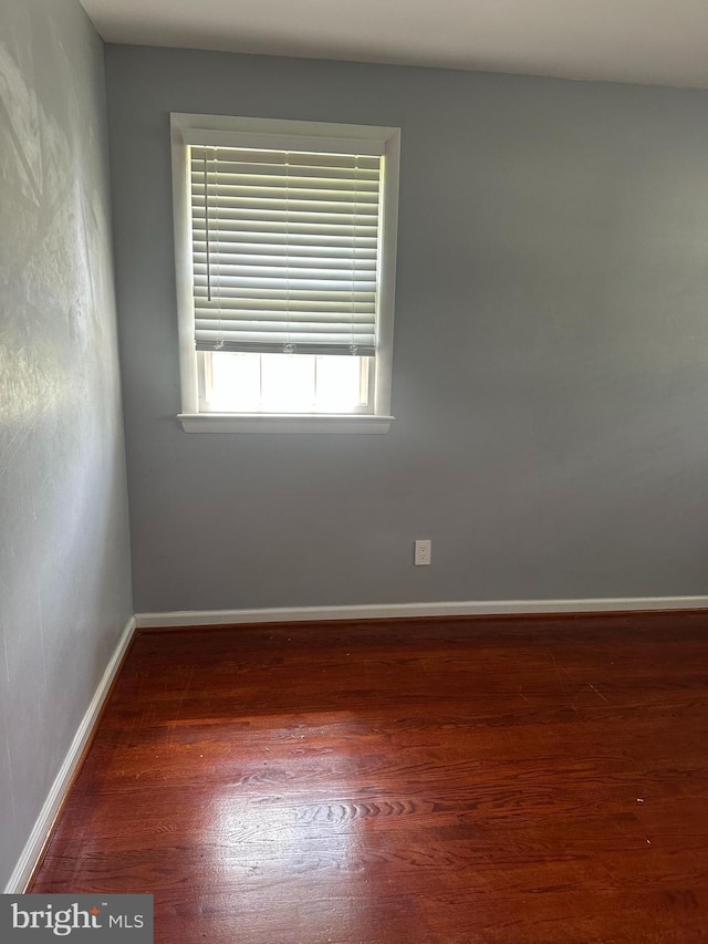 spare room featuring wood finished floors and baseboards