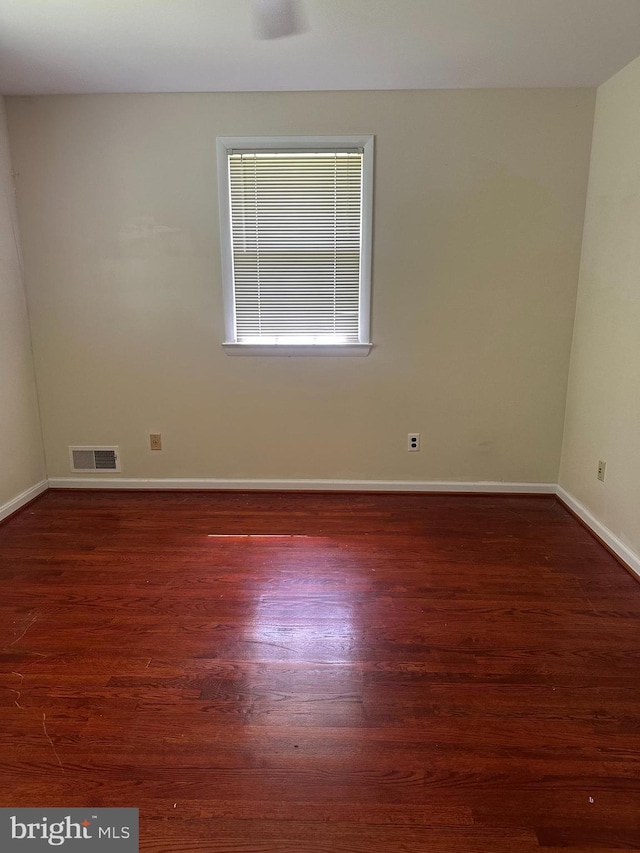 unfurnished room with wood finished floors and baseboards