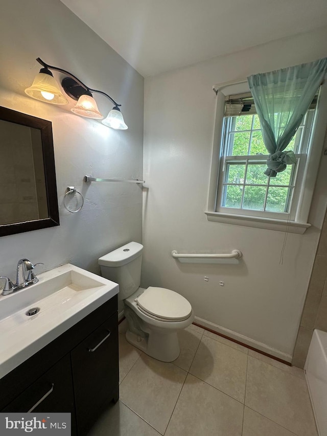bathroom with toilet, vanity, tile patterned flooring, and a tub to relax in