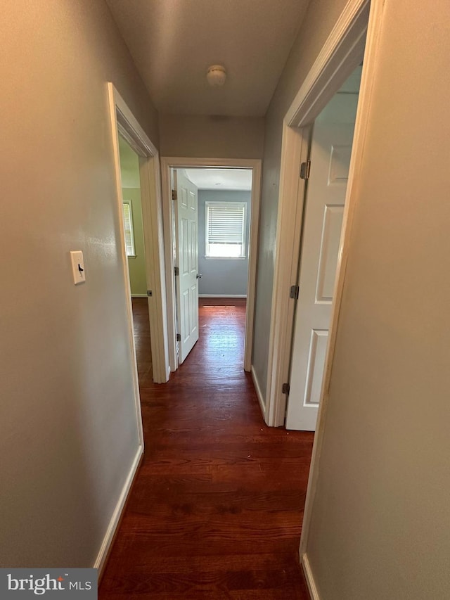 hall featuring wood finished floors and baseboards