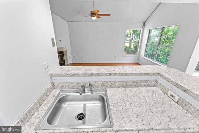 1013 Fallcrest Ct Unit 4-203, Bowie, MD 20721 - kitchen featuring a sink, ceiling fan, vaulted ceiling, light countertops, and a textured ceiling