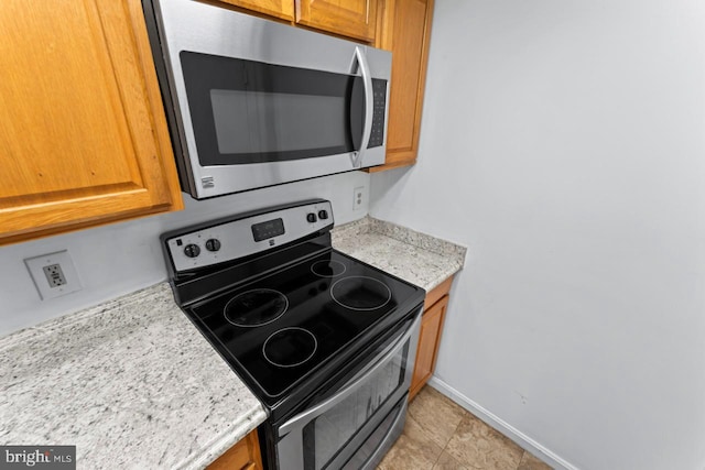 1013 Fallcrest Ct Unit 4-203, Bowie, MD 20721 - kitchen with stainless steel appliances, light countertops, brown cabinets, and baseboards