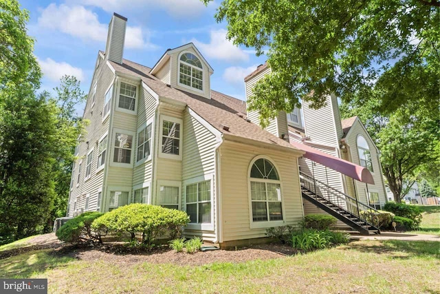 1013 Fallcrest Ct Unit 4-203, Bowie, MD 20721 - view of side of property featuring a chimney, stairs, and a shingled roof