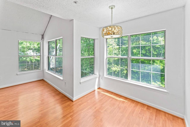 1013 Fallcrest Ct Unit 4-203, Bowie, MD 20721 - unfurnished dining area featuring a textured ceiling, light wood-style flooring, healthy amount of natural light, baseboards, and vaulted ceiling