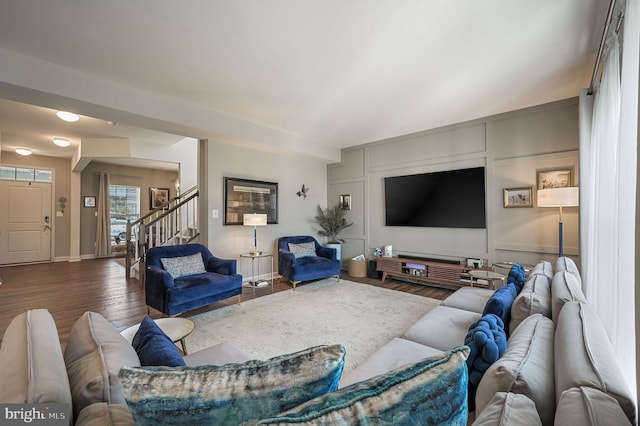 living room with stairs, wood finished floors, and baseboards