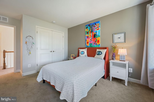 carpeted bedroom with a closet and baseboards