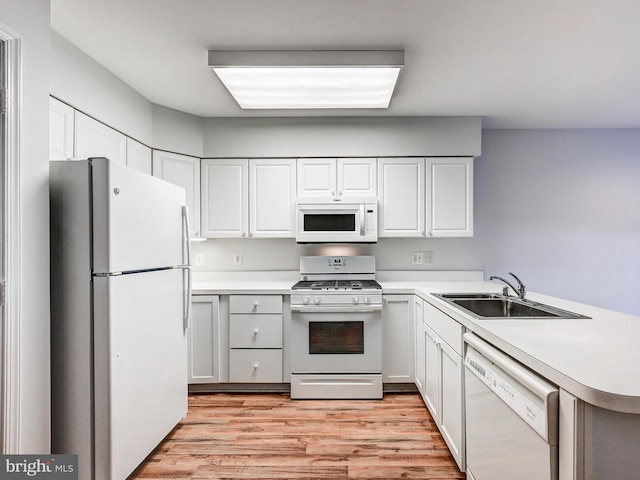 12111 Tullamore Ct Unit 101, Lutherville Timonium, MD 21093 - kitchen featuring white appliances, a sink, light wood-style floors, a peninsula, and light countertops