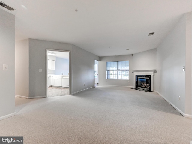 12111 Tullamore Ct Unit 101, Lutherville Timonium, MD 21093 - unfurnished living room with light colored carpet, baseboards, and a fireplace with flush hearth