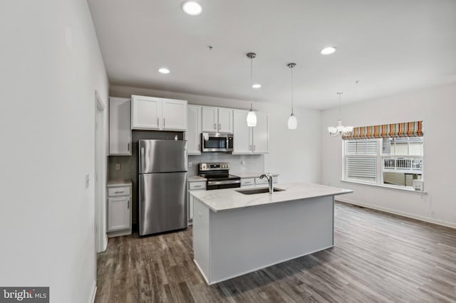 kitchen featuring appliances with stainless steel finishes, a sink, tasteful backsplash, dark wood-type flooring, and baseboards