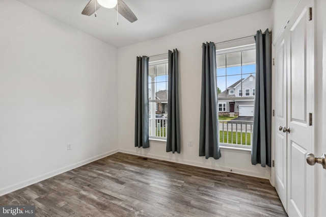 empty room featuring wood finished floors, ceiling fan, and baseboards