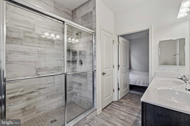 full bathroom with a stall shower, ensuite bath, wood finished floors, and double vanity