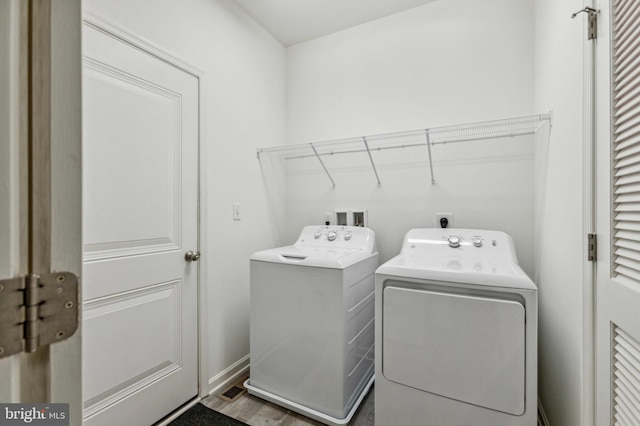 washroom featuring washing machine and dryer and wood finished floors