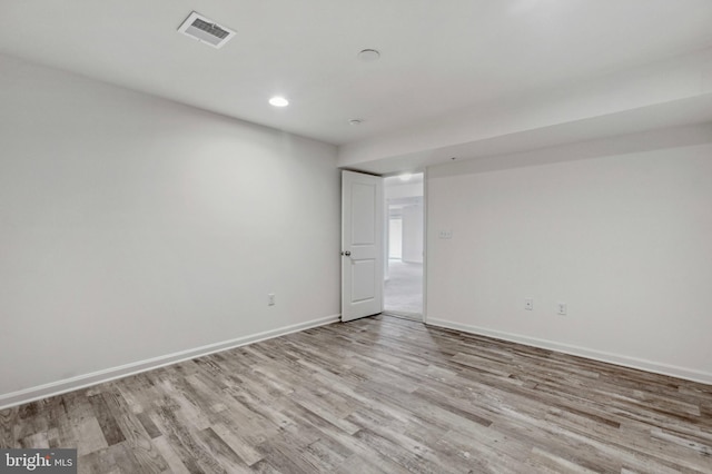 spare room featuring wood finished floors, baseboards, and recessed lighting