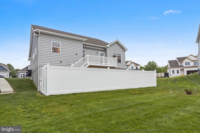 rear view of property with a shingled roof and a wooden deck