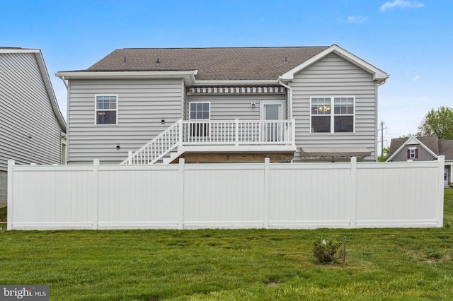 rear view of house featuring a shingled roof and a deck
