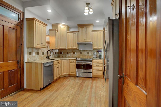 145 S Washington St, Greencastle, PA 17225 - kitchen featuring appliances with stainless steel finishes, light wood-style flooring, decorative backsplash, a sink, and light brown cabinets
