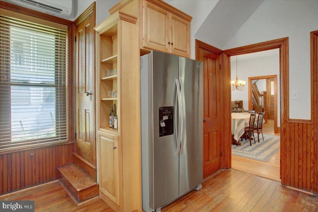 145 S Washington St, Greencastle, PA 17225 - kitchen with stainless steel fridge, a chandelier, a wall mounted AC, light wood-type flooring, and wooden walls