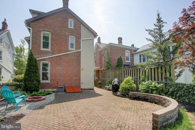 145 S Washington St, Greencastle, PA 17225 - back of house with a patio, a fire pit, brick siding, and a fenced backyard