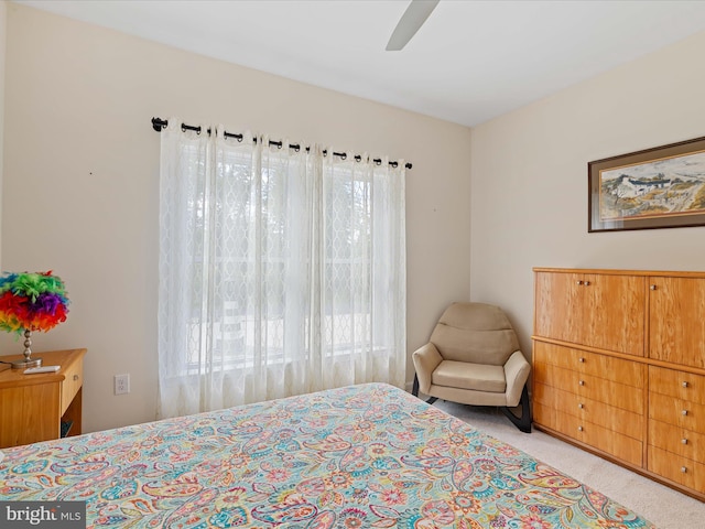 carpeted bedroom featuring multiple windows and ceiling fan