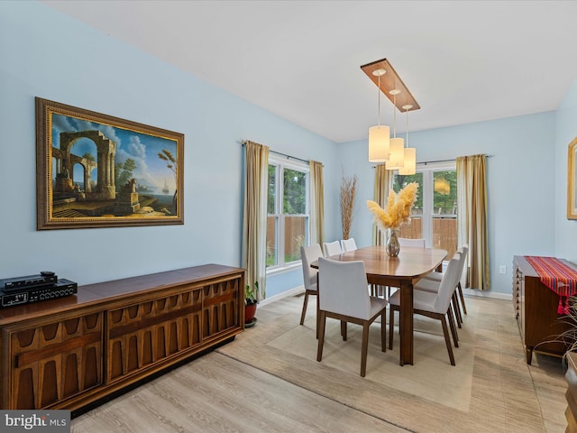 dining space with light wood finished floors and baseboards