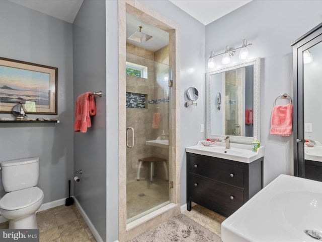 full bath featuring a stall shower, baseboards, toilet, and vanity