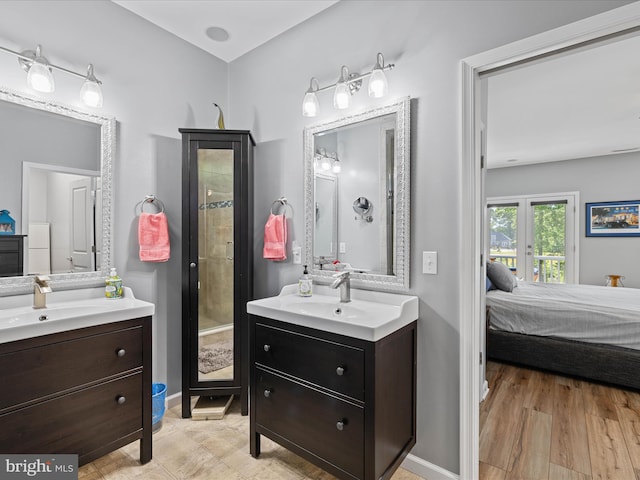 full bath with ensuite bathroom, two vanities, and baseboards