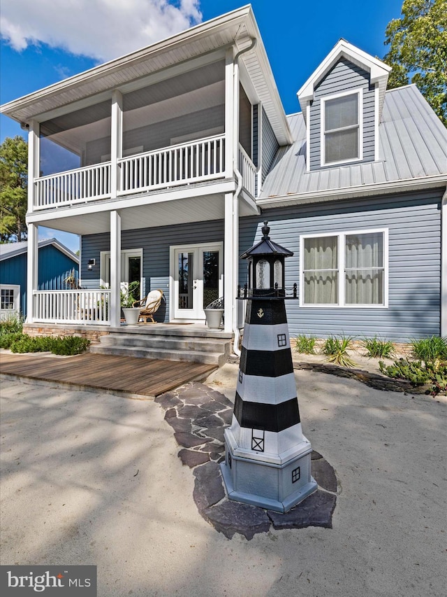 view of front of home featuring a balcony, french doors, a porch, and metal roof