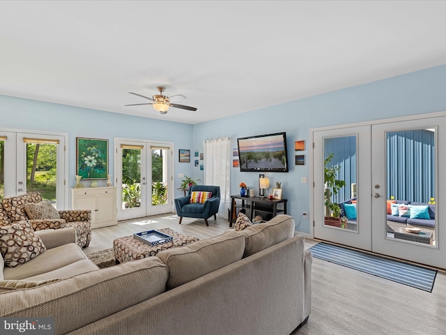 living room featuring french doors, light wood-type flooring, and plenty of natural light