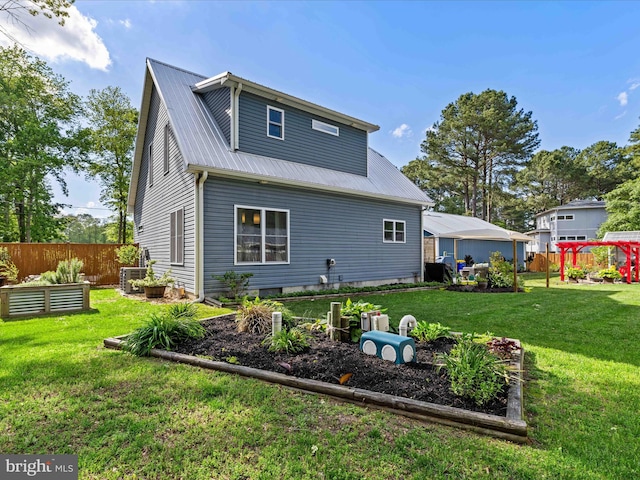 back of house with a vegetable garden and metal roof