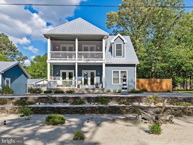 back of property with french doors, a balcony, covered porch, and metal roof