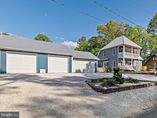 view of front of house featuring metal roof, a garage, and an outbuilding