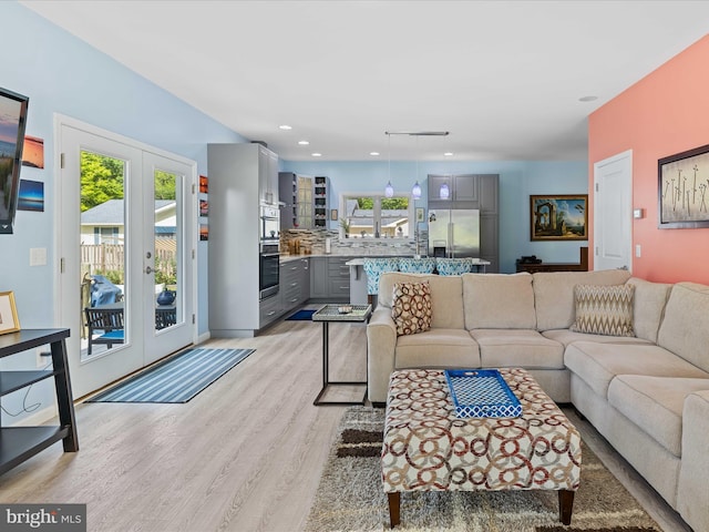 living area featuring french doors, light wood finished floors, and recessed lighting