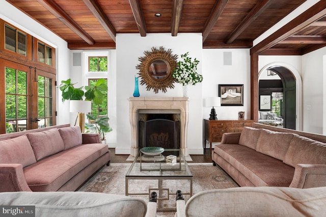 13312 Drews Ln, Potomac, MD 20854 - living room featuring wooden ceiling with exposed beams, a high end fireplace, arched walkways, wood finished floors, and french doors
