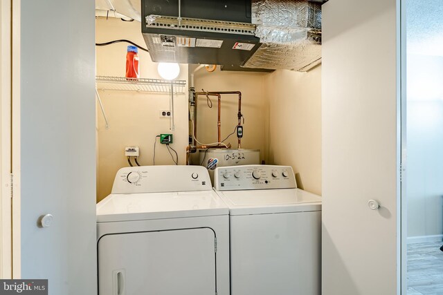 laundry room featuring washing machine and clothes dryer and wood finished floors