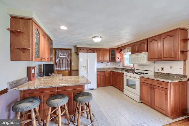 630 E Canal Rd, York, PA 17404 - kitchen with white appliances, open shelves, a sink, a peninsula, and brown cabinets