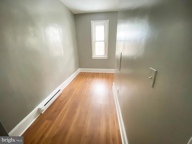 hall featuring light wood finished floors and baseboards