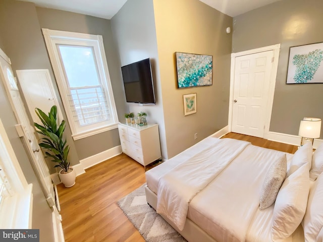 bedroom with light wood-type flooring and baseboards